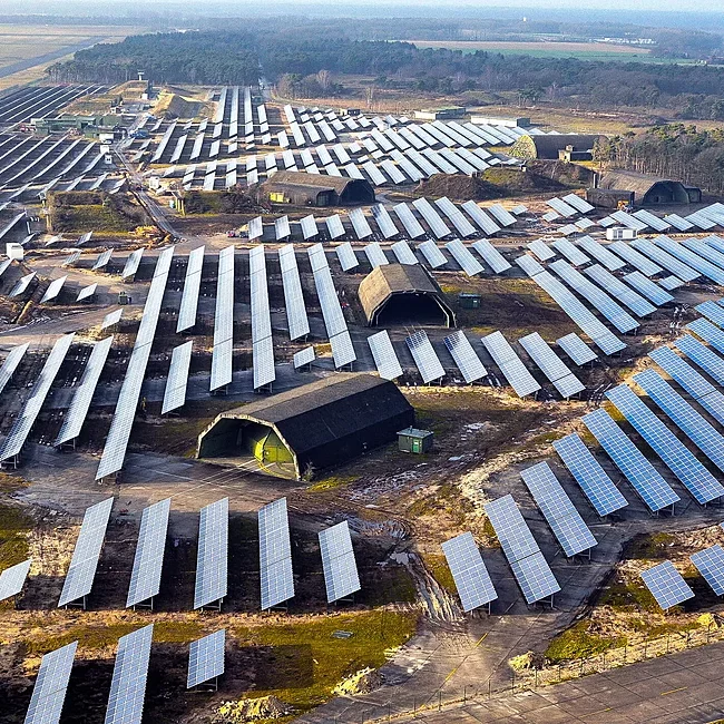 Großflächige Photovoltaikanlage auf einem Feld inmitten einer Bunkeranlage am Flughafen Weeze aus der Vogelperspektive.